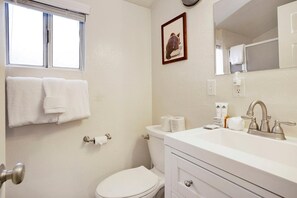 A bathroom with a toilet, sink, and a towel rack. - Our Cabin In The Woods #2476 (Big Bear Lake)