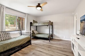 A room with bunk beds, a desk, a ceiling fan, and a window with curtains. - Wildwood Lodge #2087 (Big Bear Lake)
