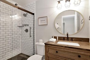 A bathroom with a shower, toilet, sink, and a mirror. - Wildwood Lodge #2087 (Big Bear Lake)