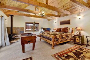 Una habitación acogedora con una cama, mesa de fútbol de mesa, chimenea y ventana con vistas.