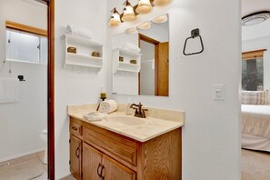 A bathroom with a wooden vanity, a large mirror, and a towel rack. - Casa Bosque #2176 (Big Bear Lake)