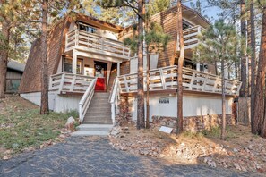 A two-story house with a stone foundation, a wooden deck, and a red door. - Fox & Bears Retreat#2190 (Big Bear Lake)