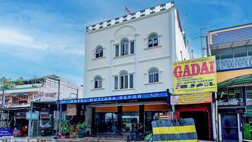 A multi-story building with a sign for 'Hotel Mutiara Depok' and a 'Super Artha Gadai' store.
