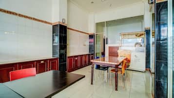 A restaurant with a long counter, wooden cabinets, and a glass display case.