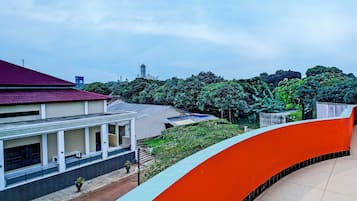 A building with a red roof, a white facade, and a curved orange structure.