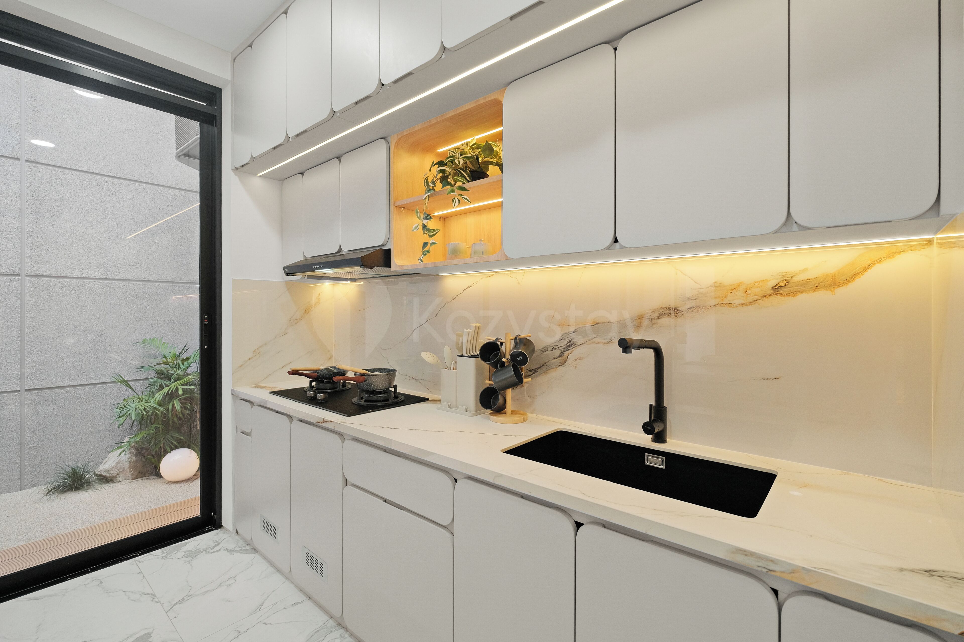 Eine moderne Küche mit einem schwarzen Spülbecken, weißen Schränken und einer Marmor-Spritzschutzwand.