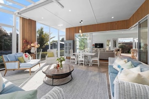 A spacious living area with a round coffee table, seating arrangements, and a television.