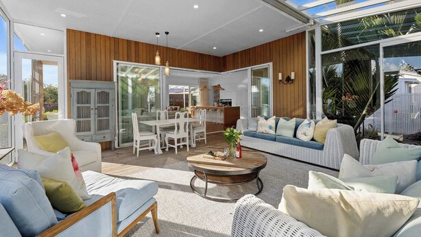 A modern living room with a dining area, large windows, and a view of the outdoors. - Luxury On Lemon (New Plymouth)
