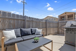 A patio area with a sofa, a small table, and a grill. - Sandpiper Dune Escape - Steps to the Beach & Dunes - 5 Bedrooms (Oceano)