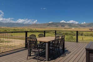 Eine Terrasse mit Tisch und Stühlen mit Blick auf eine reizvolle Landschaft.