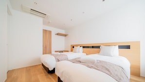 Una habitación de hotel moderna con una cama grande, mesitas de noche y aire acondicionado integrado.