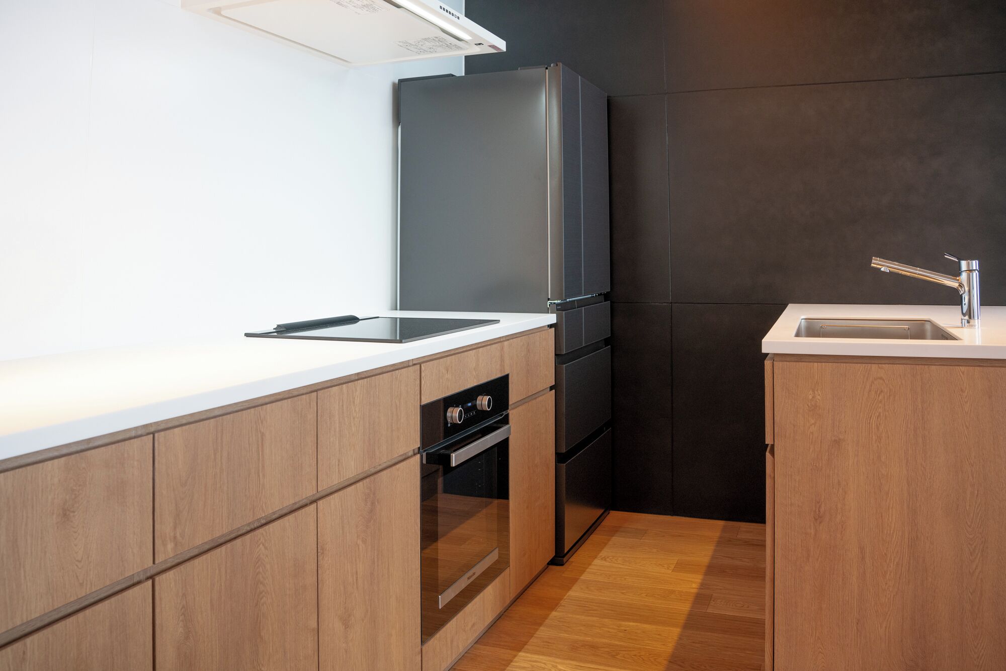 A modern kitchen with a built-in oven, a dishwasher, and a sink.