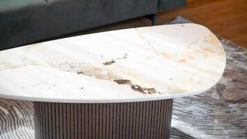 Una sala de estar moderna con un sofá gris y una mesa de centro de mármol.