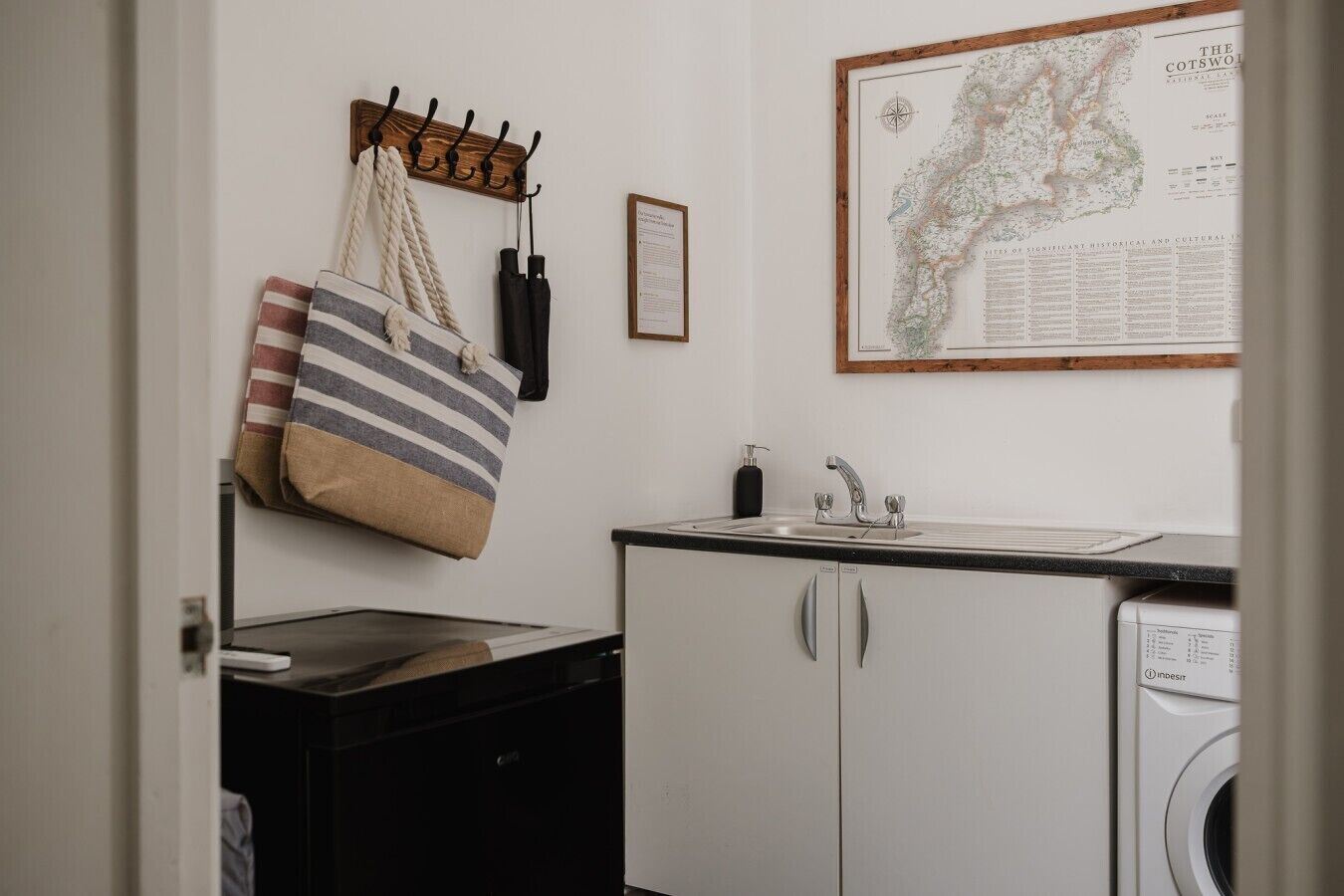 Un área de lavandería con lavadora, un lavamanos y un mapa en la pared.