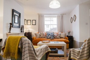 A living room with a sofa, chairs, a coffee table, and a window with curtains. - Beautiful Cottage in the Heart of Malmesbury (Malmesbury)