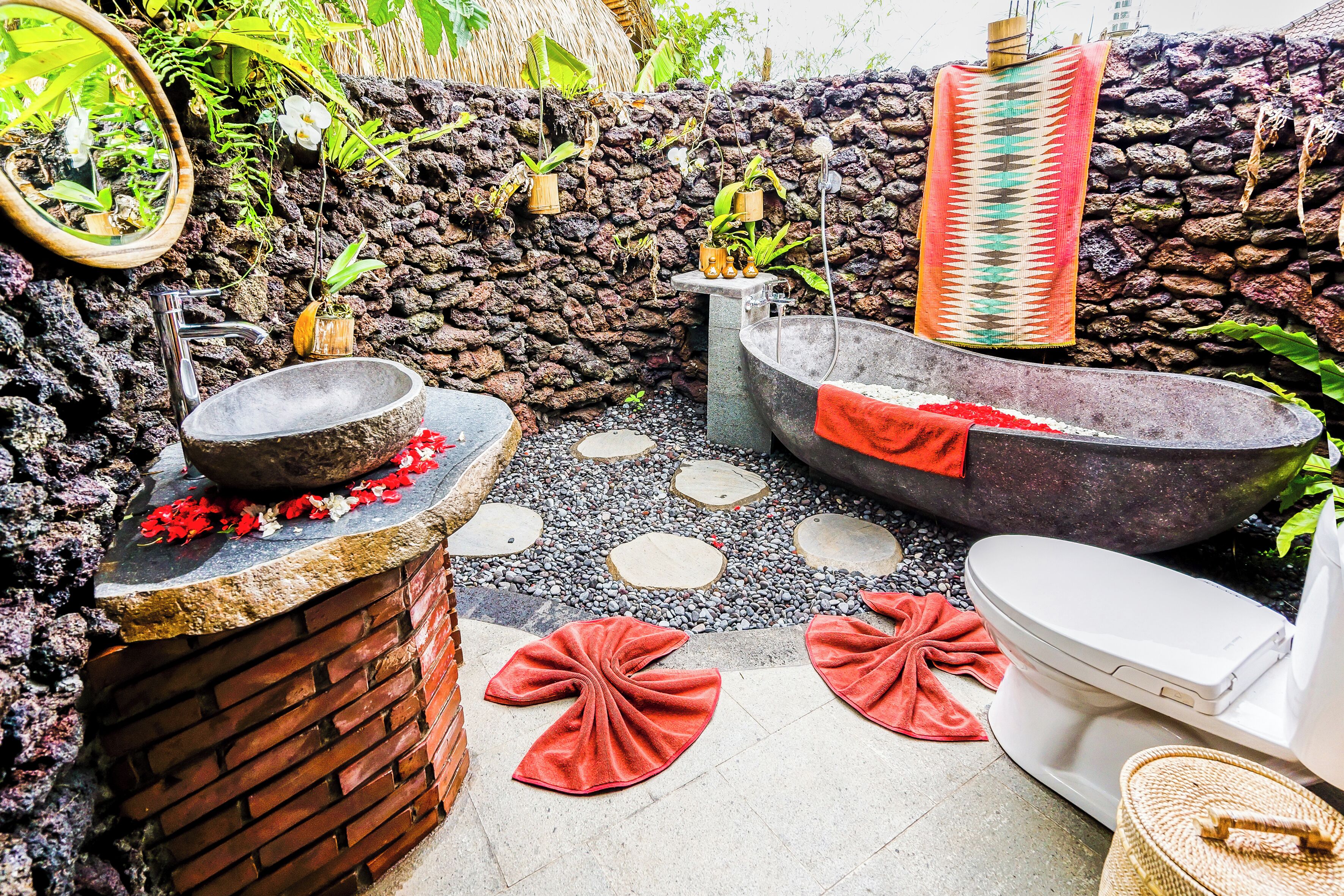 A bathroom with a stone sink, a bathtub, and a toilet.