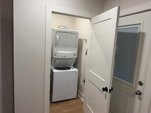 A laundry room with a washer and dryer, a door with a window, and a light switch on the wall. - Harrington: 1 Min From Main Entrance to Texas A&M (College Station)