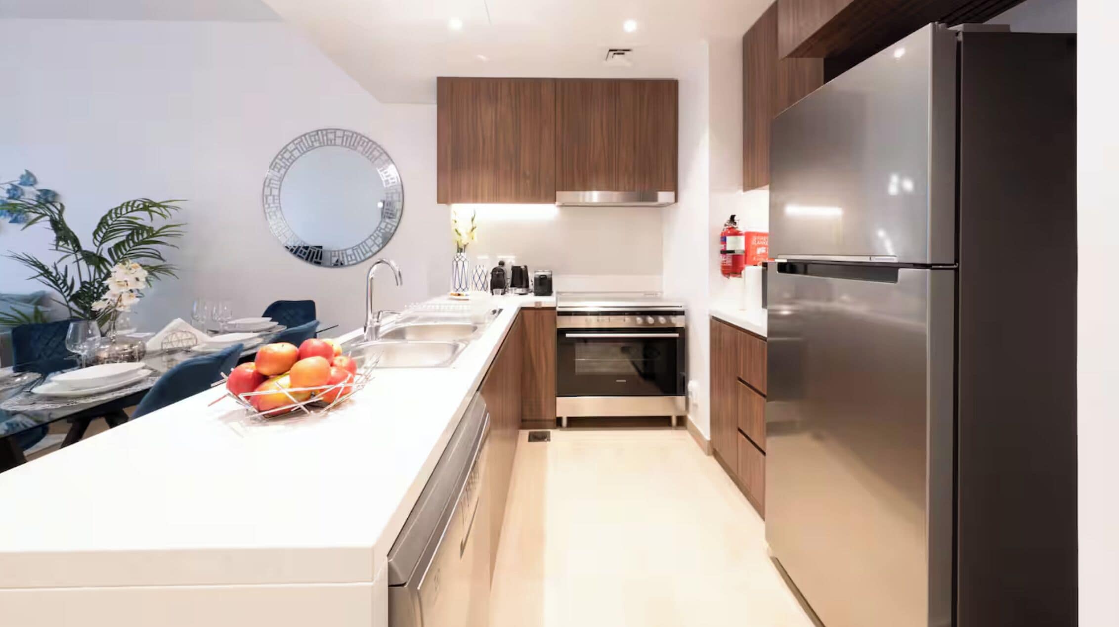 Een moderne keuken met een centraal eiland, roestvrijstalen apparatuur en houten kastjes.