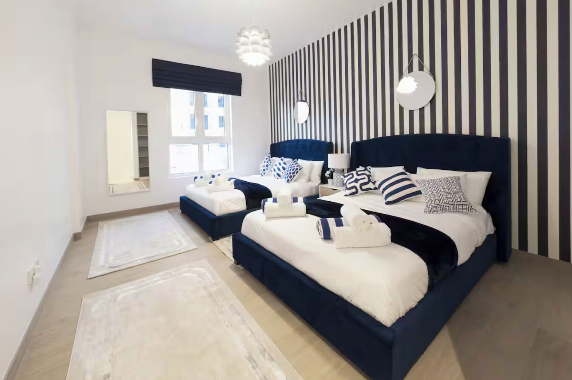 Ein modernes Schlafzimmer mit einem großen Bett, Nachttischen und einer gestreiften Wand.