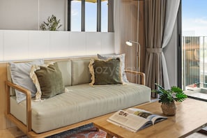 Ein modernes Wohnzimmer mit einer Couch, einem Couchtisch und einer Zimmerpflanze.