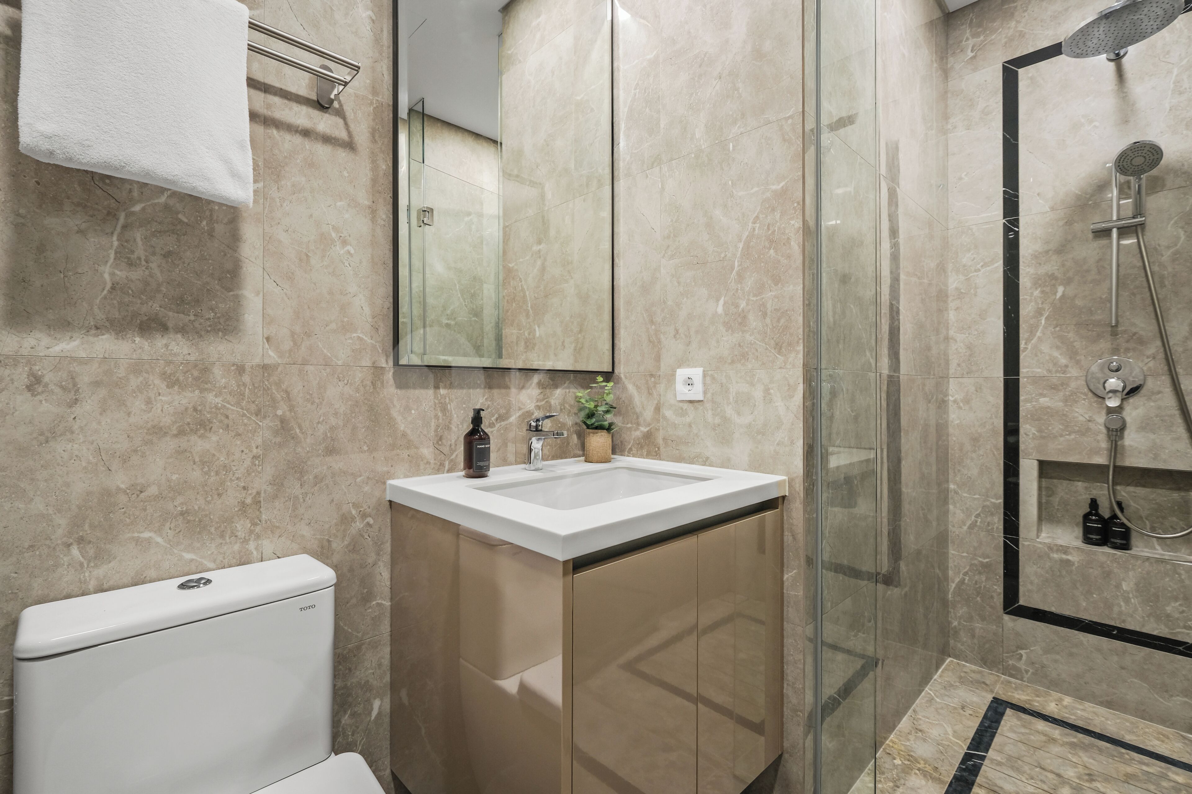 Ein modernes Badezimmer mit Toilette, Waschbecken und Dusche.