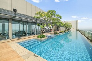 Ein Dachpool mit freiem Blick auf die Stadtlandschaft, umgeben von modernen Gebäuden und Glasgeländern.