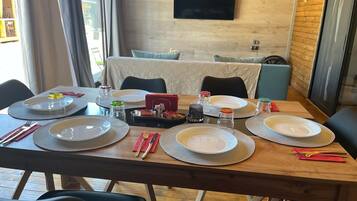 A dining table set for four with plates, cutlery, and condiments.