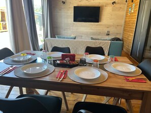 A dining table set for four with plates, cutlery, and condiments.