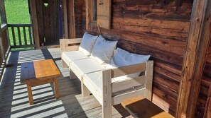 Eine Holzterrasse mit einer Couch und einem Tisch.