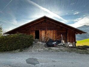 Eine Holzhütte mit geneigtem Dach, einer Tür und einer kleinen Veranda.