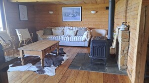 Ein gemütliches Zimmer mit einer Couch, einem Tisch und einem Kamin.