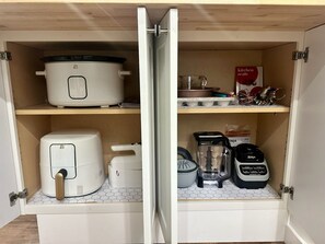 Eine Küche mit Einbauofen, Reiskocher, Lebensmittelfürhrex und Mixer.