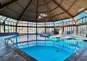 Ein Hallenbad mit Holzboden und großen Fenstern.