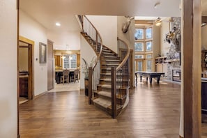 A spacious interior with a wooden staircase, a dining area, and a pool table. - Buffalo Teal Lodge|Hot Tub|Resort Amenities (Klamath Falls)