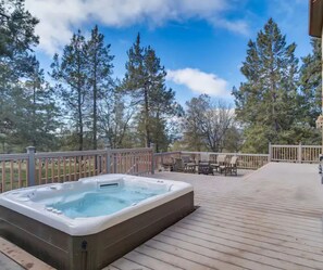 A hot tub on a wooden deck with a view of tall trees and a clear sky. - Buffalo Teal Lodge|Hot Tub|Resort Amenities (Klamath Falls)