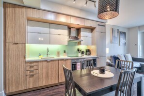 A modern kitchen with wooden cabinetry, a central island, and a dining area with chairs.