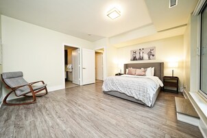 A spacious bedroom with a large bed, a rocking chair, and a walk-in closet.
