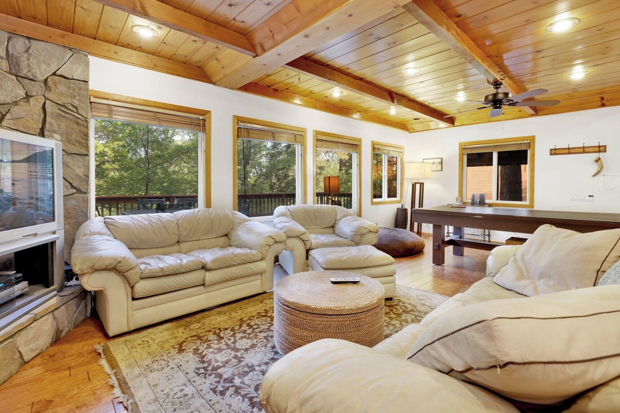 Amplia sala de estar con chimenea, asientos cómodos y ventanas grandes.