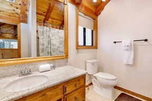 A bathroom with a wooden vanity, a sink, a toilet, and a towel rack. - Bearfoot Lodge #2030 (Big Bear Lake)
