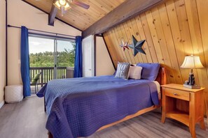 A bedroom with a bed, a nightstand, a lamp, and a star decoration on the wall. - Bear Cabin #1976 (Big Bear Lake)