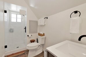 A bathroom with a white bathtub, toilet, and shower area. - Green Canoe Cabin #2293 (Big Bear Lake)