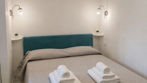 Een hotelkamer met een bed, twee bedlampen en een hoofdeinde.