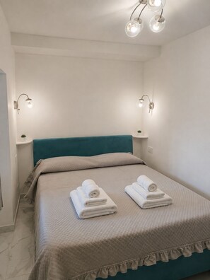 Ein Hotelzimmer mit einem Bett, zwei Nachttischlampen und einem Kopfteil.