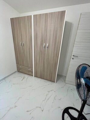Ein Zimmer mit Schrank, Ventilator und Marmorboden.