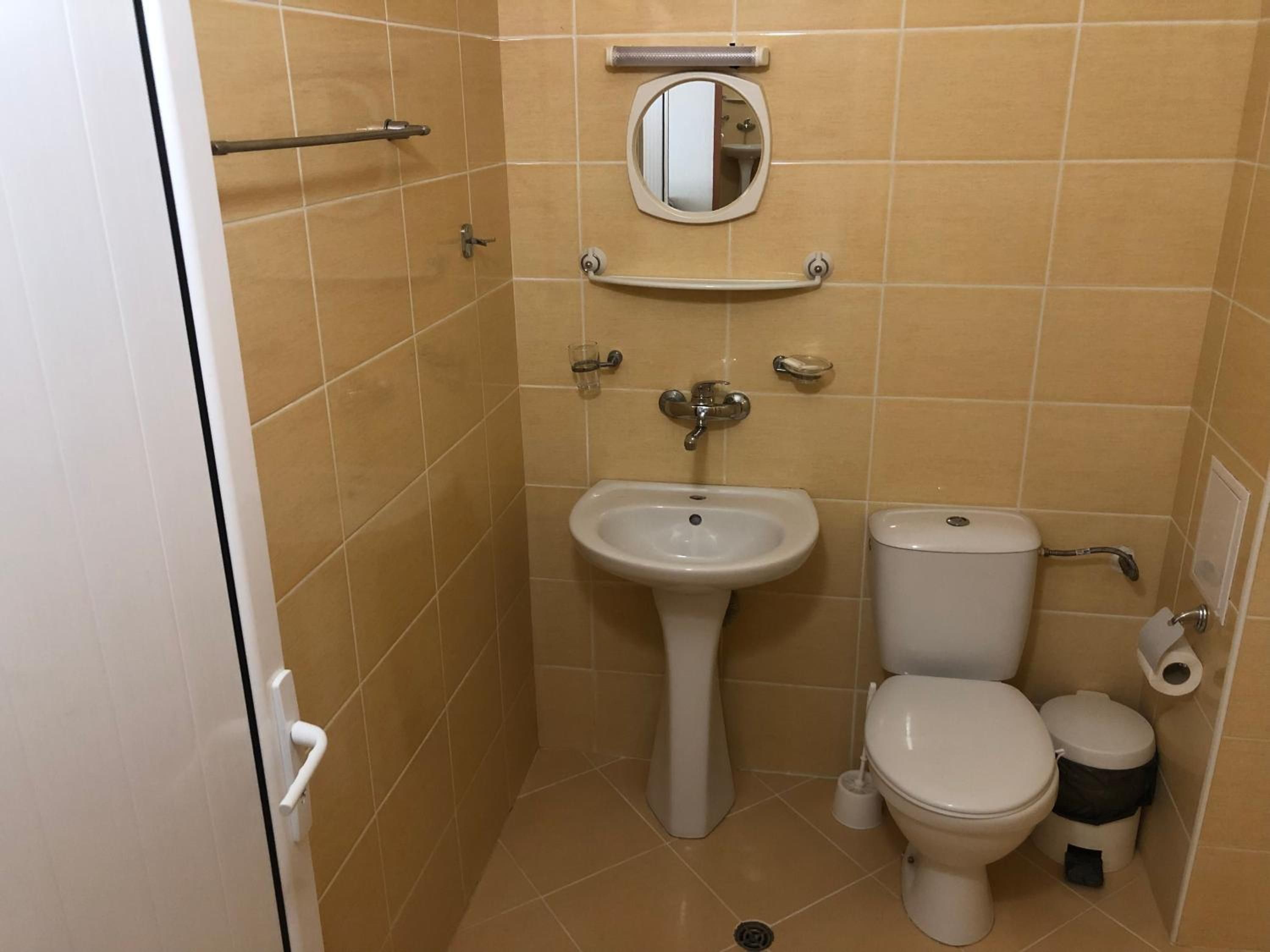 Un baño pequeño con lavamanos, inodoro y espejo.