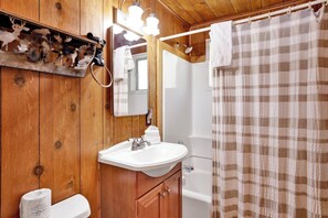 A wooden bathroom with a sink, mirror, and shower curtain. - Sunny Bear Cabin #1970 (Big Bear Lake)