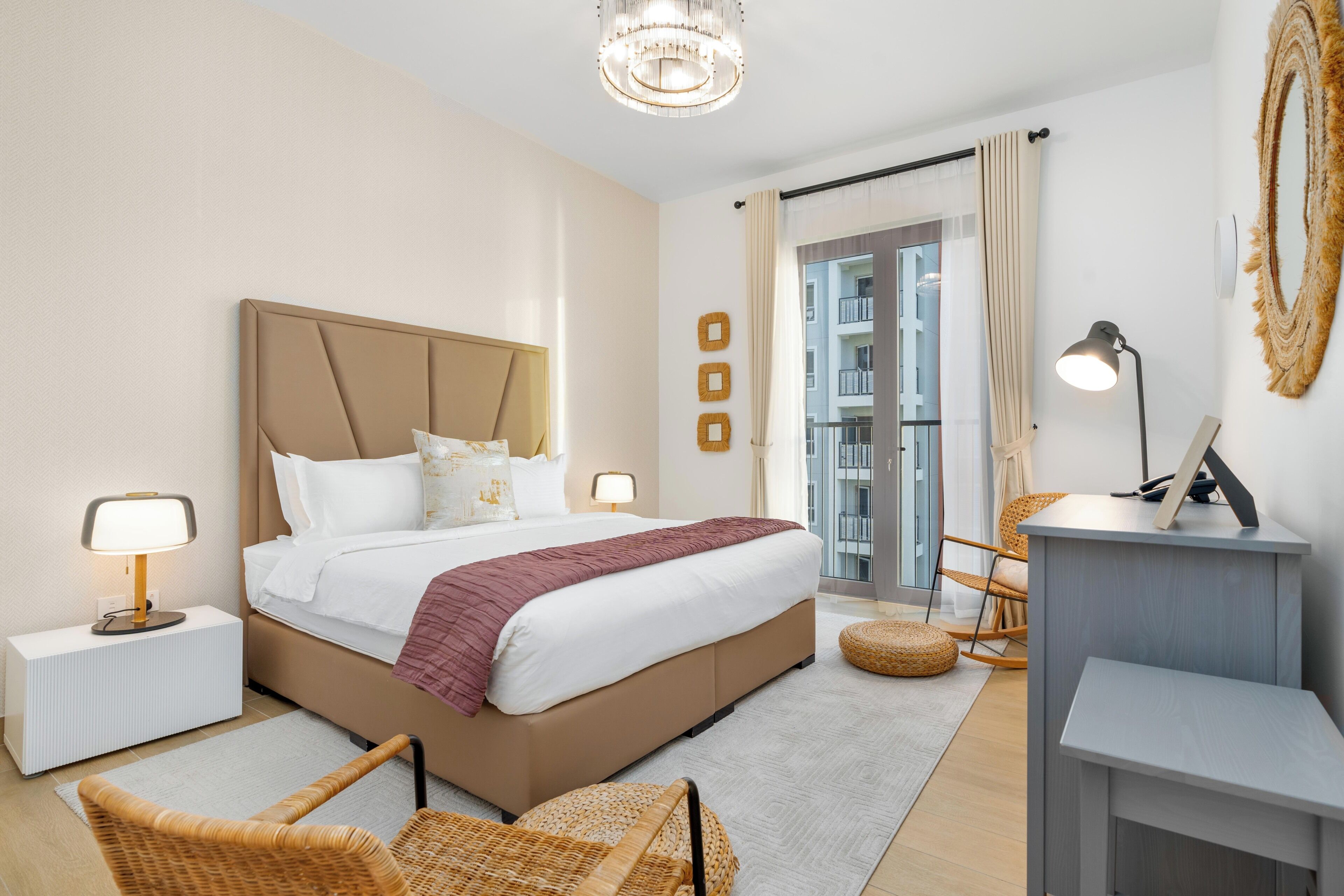 A modern hotel room with a large bed, bedside lamps, a desk, and a view of the city.