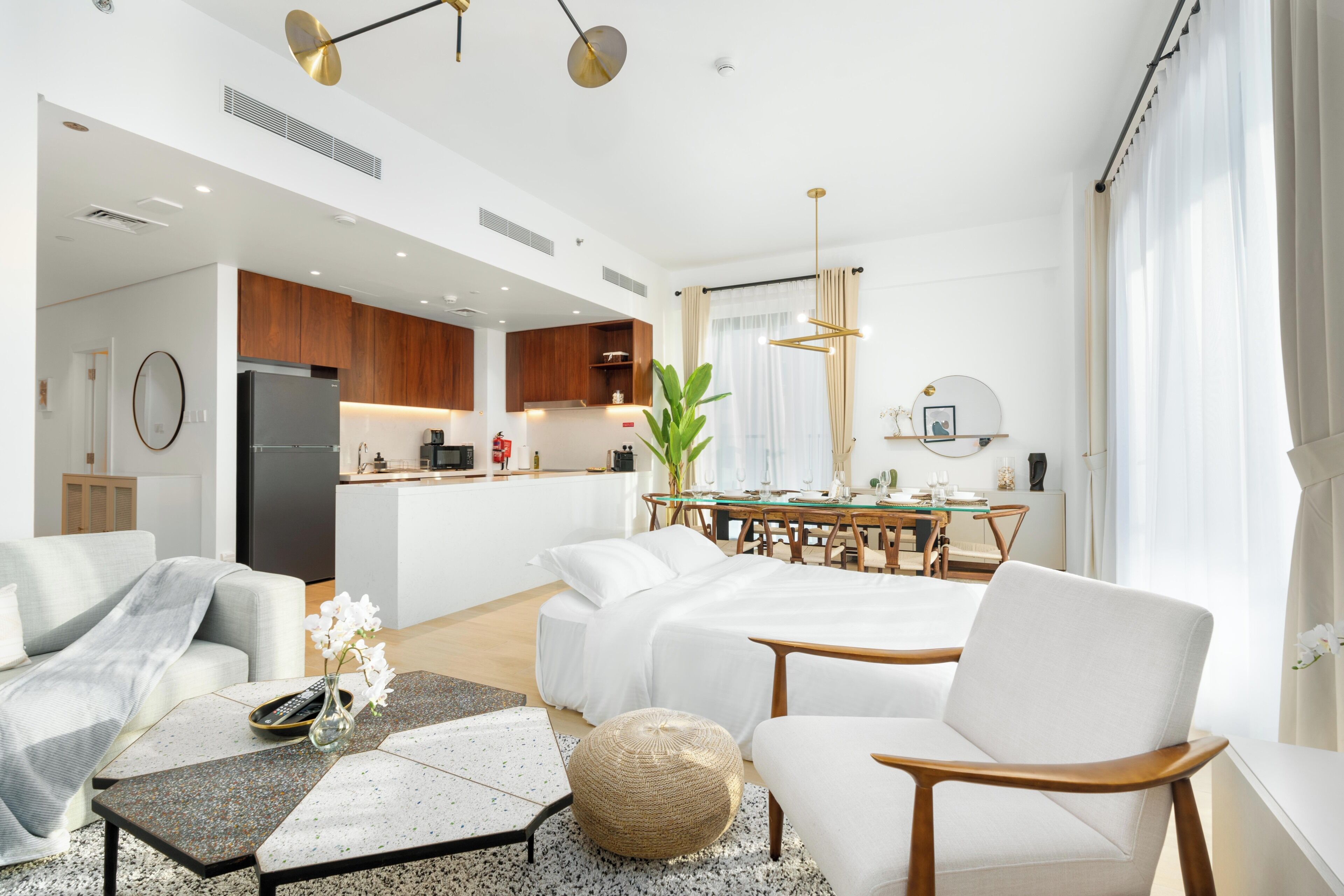 Una habitación de hotel moderna con kitchenette, zona de comedor y sala de estar.
