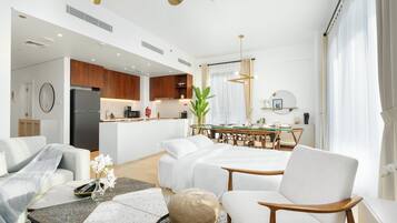 Una habitación de hotel moderna con kitchenette, zona de comedor y sala de estar.