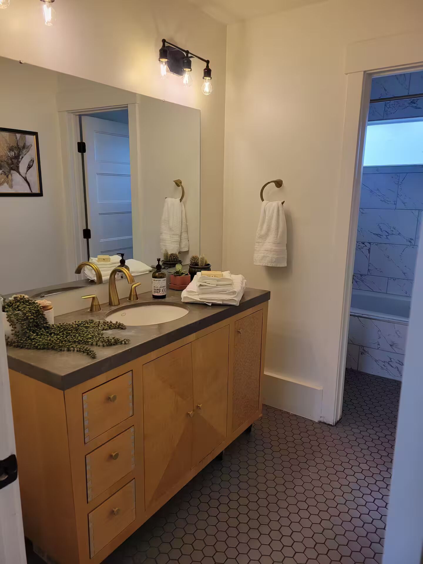 Un bagno con doppio lavabo, uno specchio e vista su un balcone.